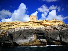 Tarp uolų saule mėgaujasi turistai. Malta