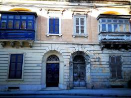 Namas su tipiškomis durimis ir balkonais. Sena ir atnaujinta dalis. Malta